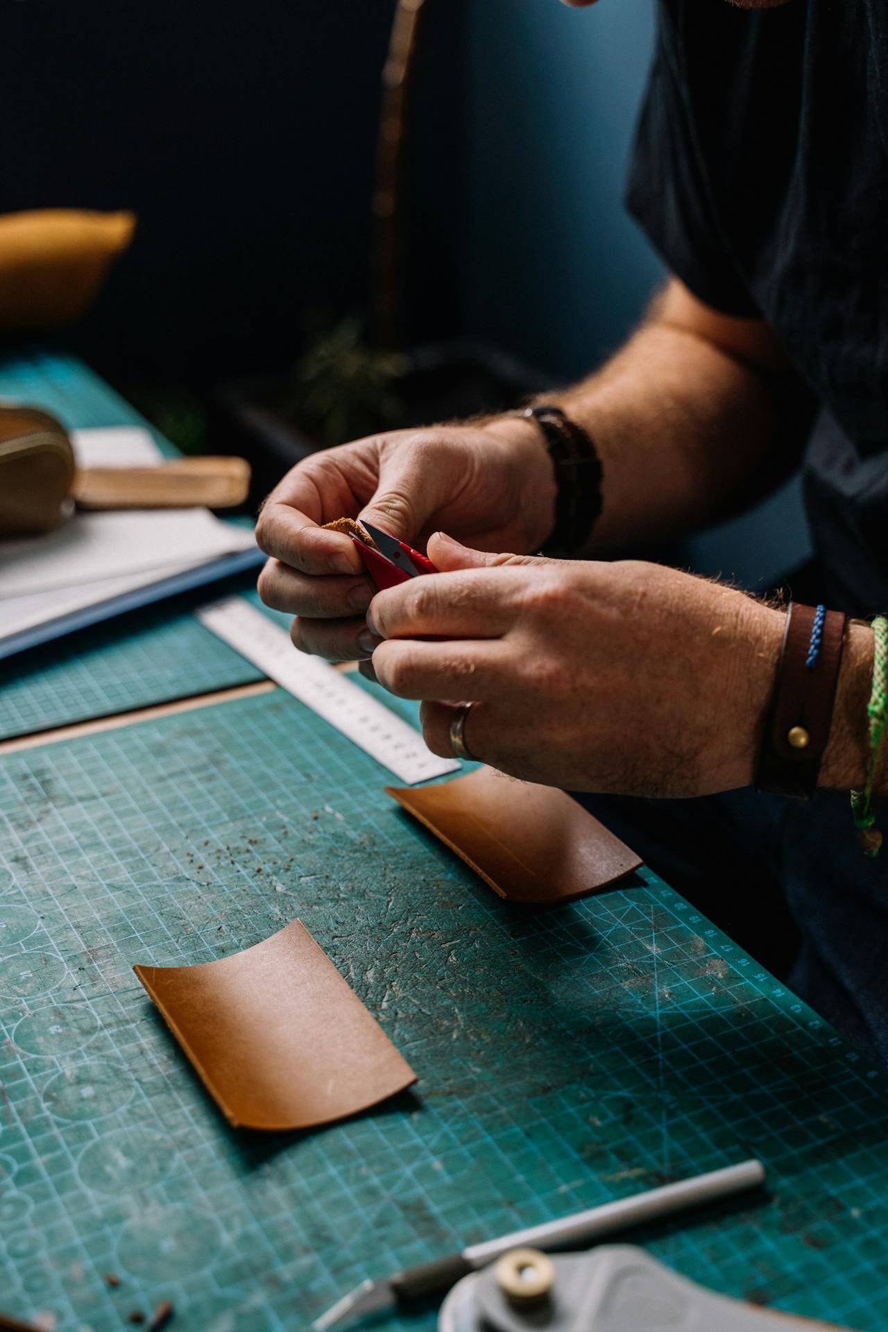 Person making custom leather goods showcasing value of precise craftmenship